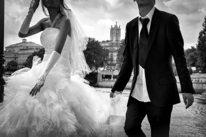 Bride and groom on Île Saint Louis, Paris, with the River Seine in the background.